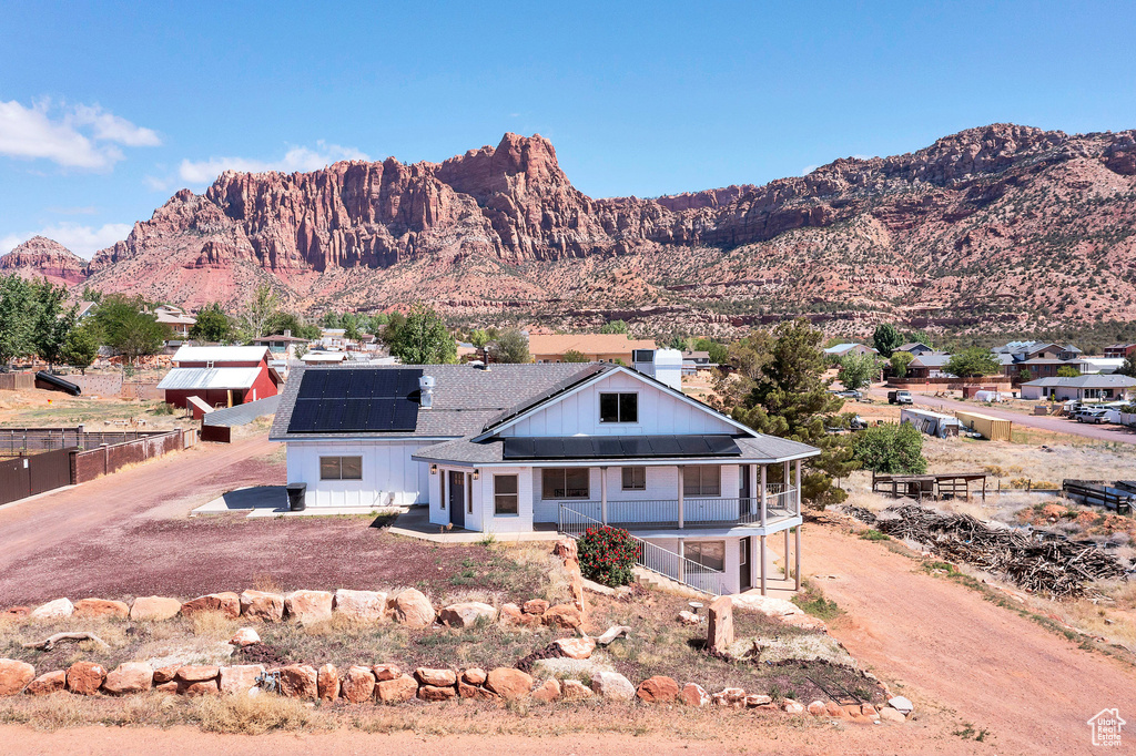View of front of house featuring solar panels and a mountain view
