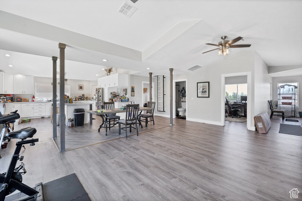 Dining room featuring a ceiling fan, recessed lighting, light wood finished floors, baseboards, and vaulted ceiling