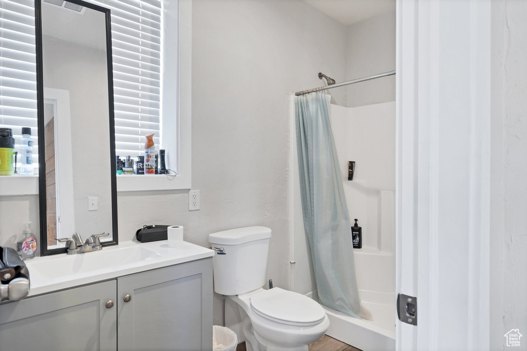 Full bathroom with a shower with curtain, vanity, and toilet