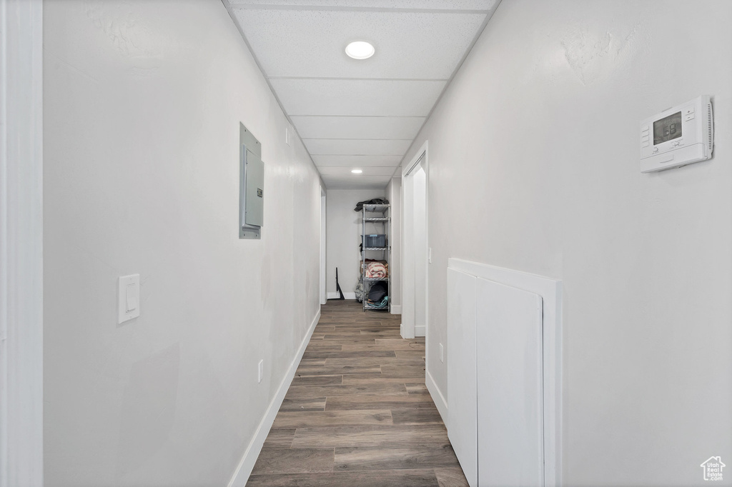 Hall featuring dark wood-style floors, recessed lighting, electric panel, and baseboards