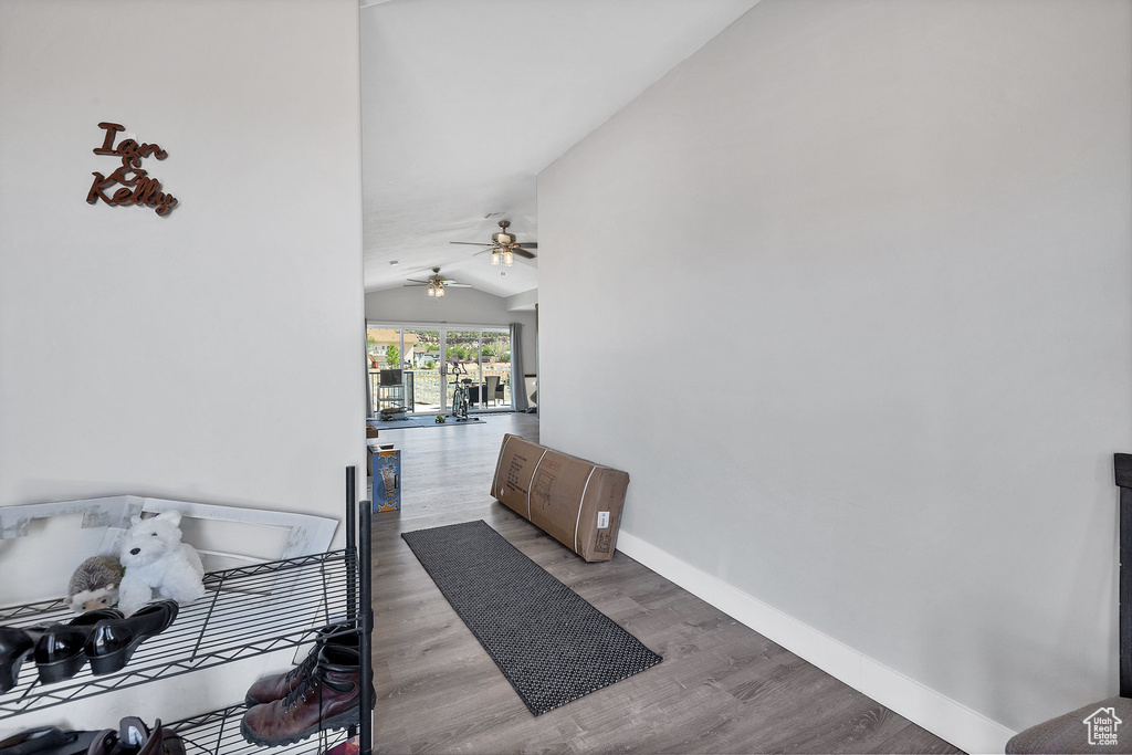 Hall featuring lofted ceiling, wood finished floors, and baseboards