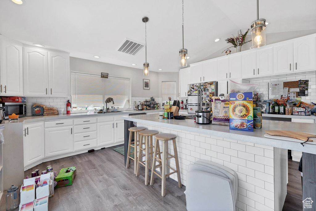 Kitchen with a sink, a breakfast bar area, stainless steel appliances, backsplash, and recessed lighting