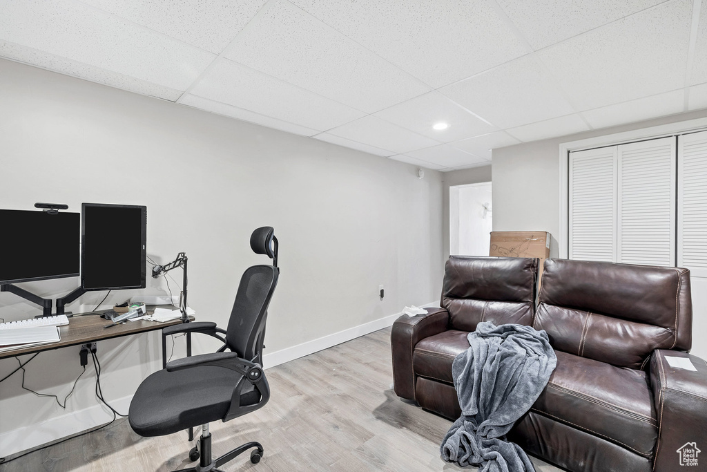 Office with a drop ceiling, light wood-style flooring, and baseboards