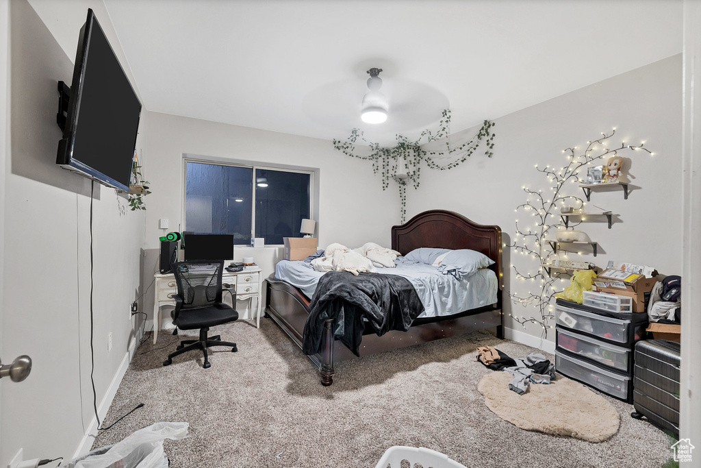 Carpeted bedroom with ceiling fan and baseboards