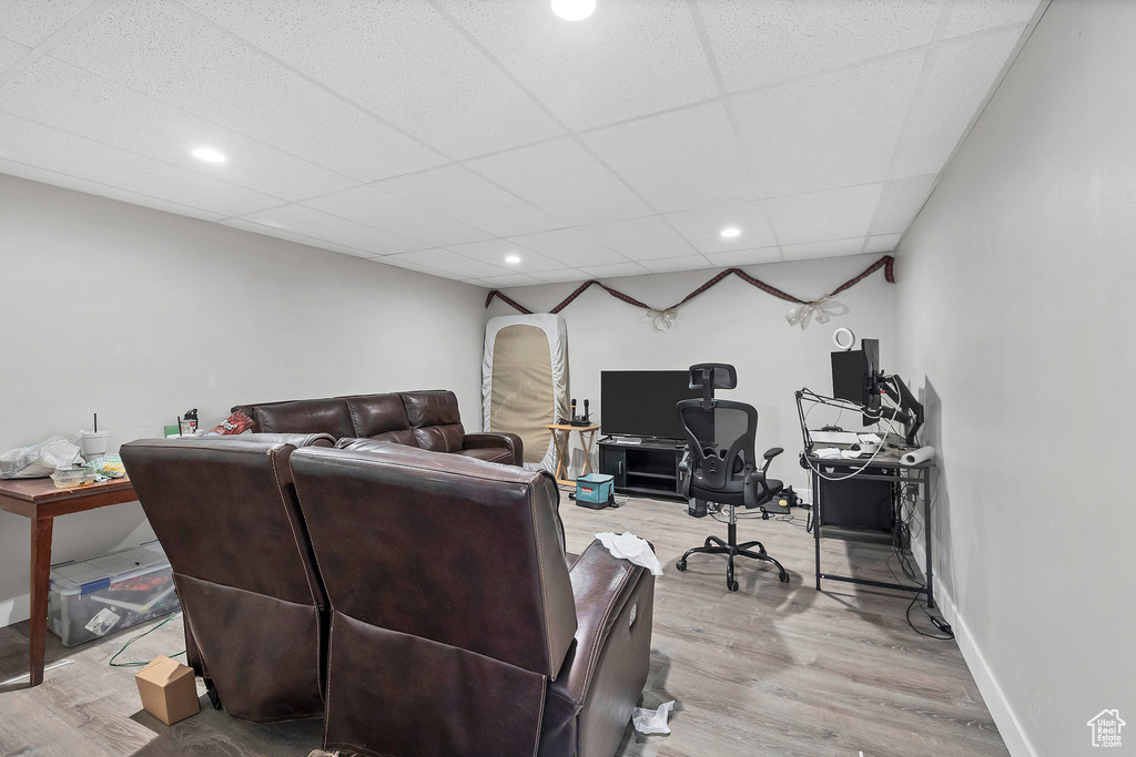 Living room with a desk, wood finished floors, a drop ceiling, recessed lighting, and baseboards
