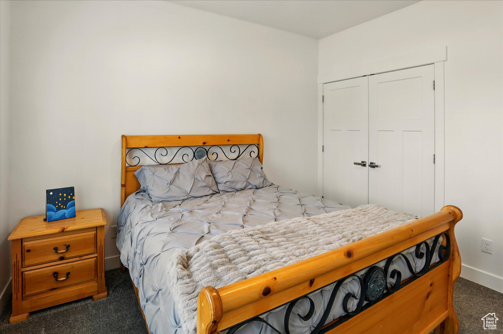 Bedroom featuring carpet flooring, baseboards, and a closet
