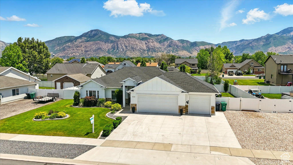 View of front of home with a residential view, a garage, board and batten siding, concrete driveway, and a mountain view