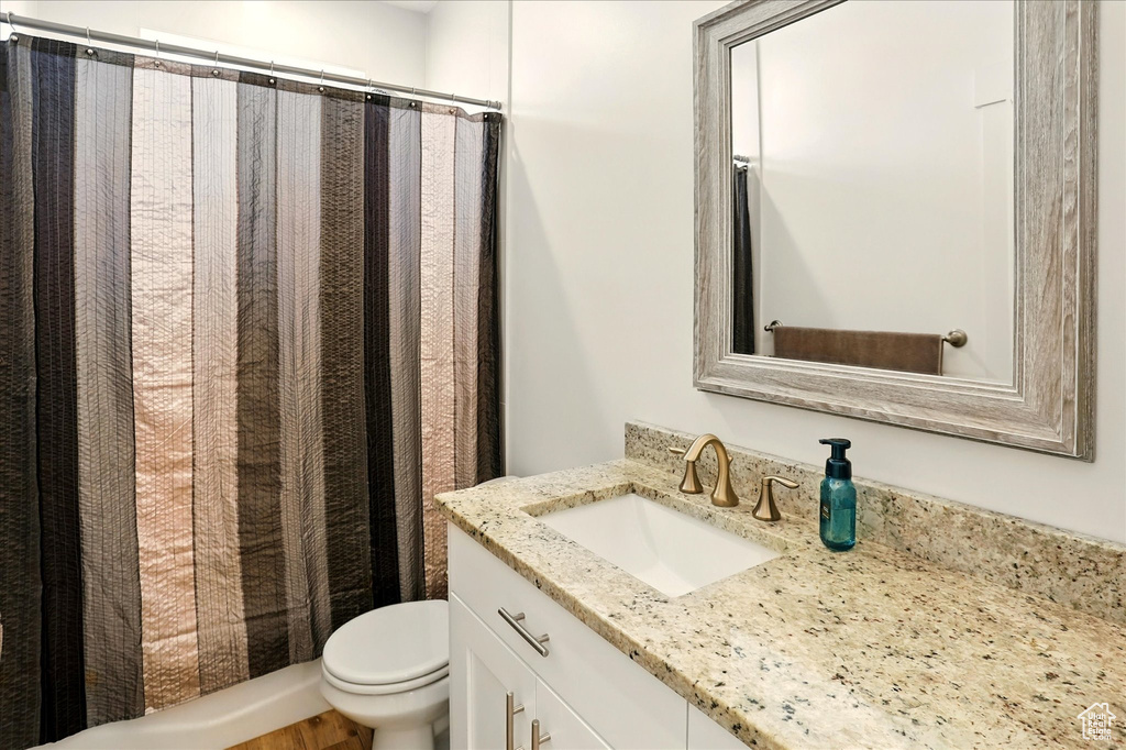Bathroom with vanity, toilet, and a shower with curtain