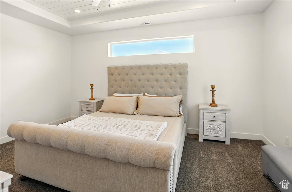 Bedroom featuring dark colored carpet, baseboards, a tray ceiling, and recessed lighting