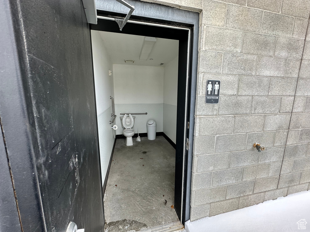 Bathroom featuring concrete flooring and toilet