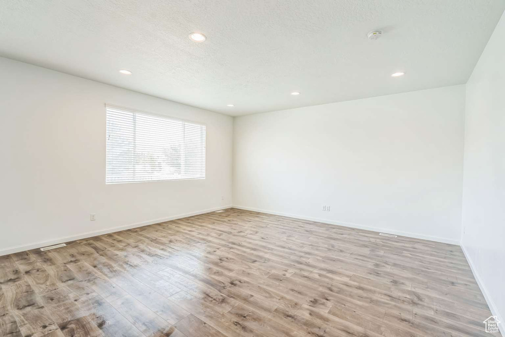 Unfurnished room with wood finished floors, recessed lighting, and a smoke detector