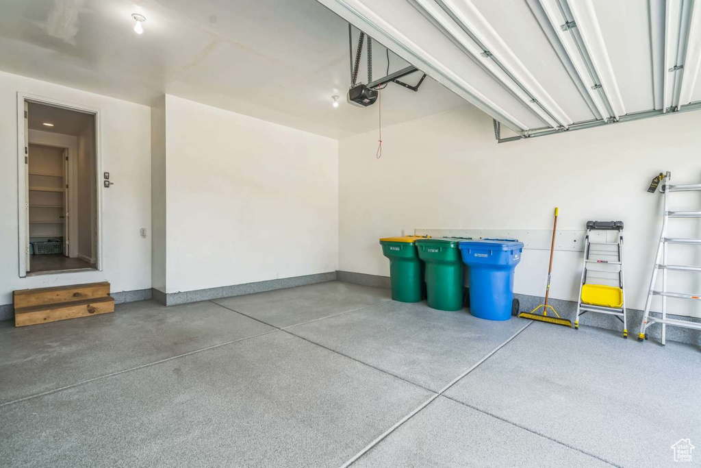 Garage featuring a garage door opener and baseboards
