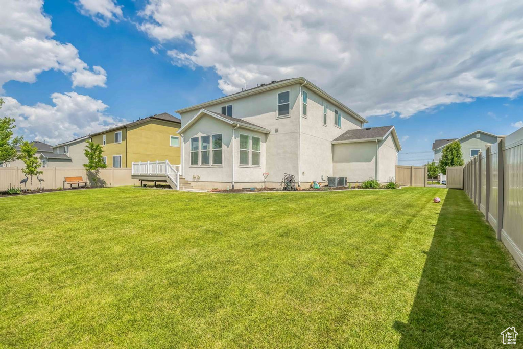 Rear view of house featuring a fenced backyard and stucco siding