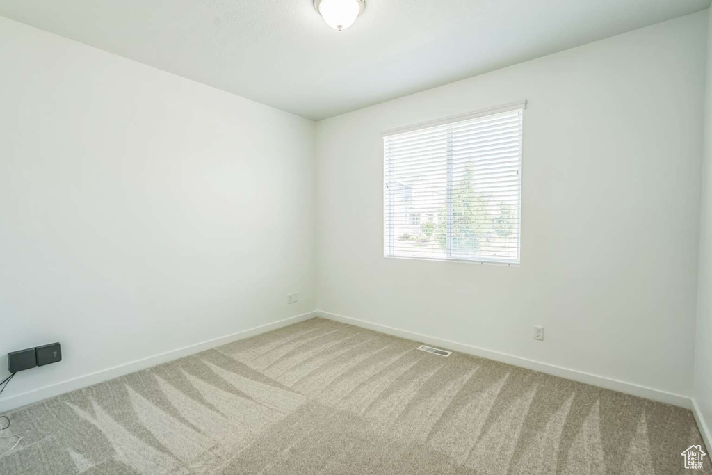 Spare room with light carpet and baseboards