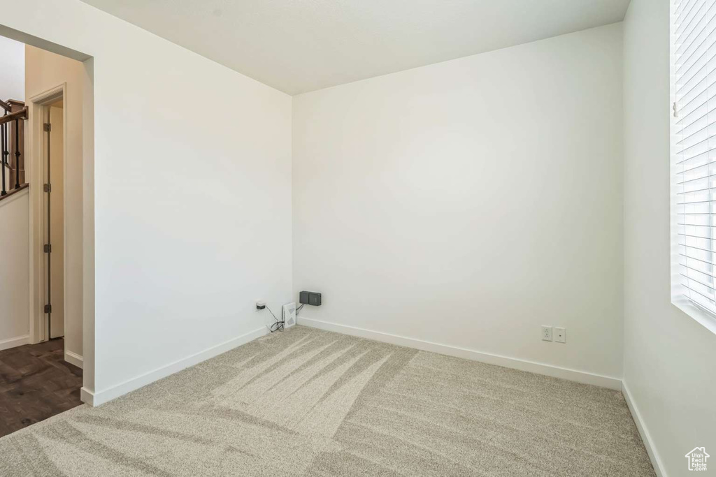 Carpeted spare room featuring baseboards