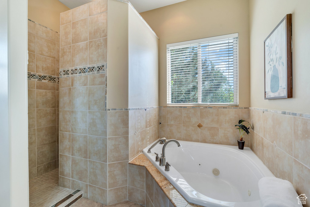 Full bathroom with a jetted tub and tiled shower