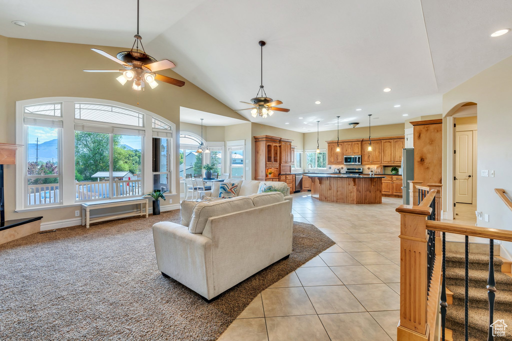 Living room featuring ceiling fan, light tile patterned floors, vaulted ceiling, recessed lighting, and arched walkways