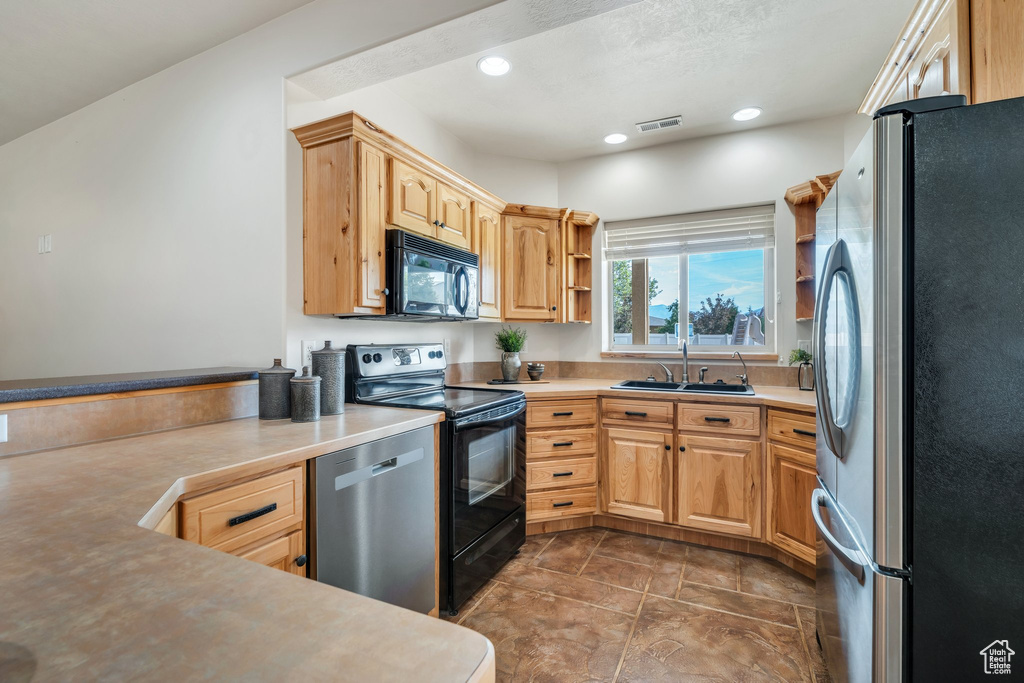 Kitchen with black appliances, a sink, open shelves, light countertops, and recessed lighting