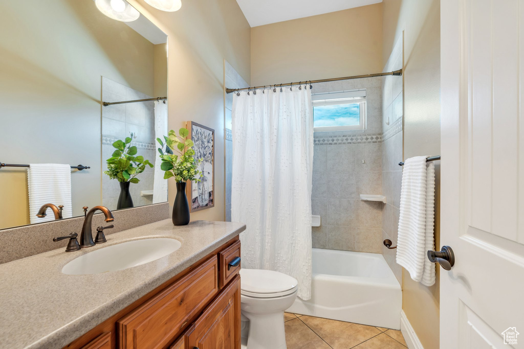 Full bathroom featuring tile patterned flooring, vanity, toilet, and shower / bath combination with curtain