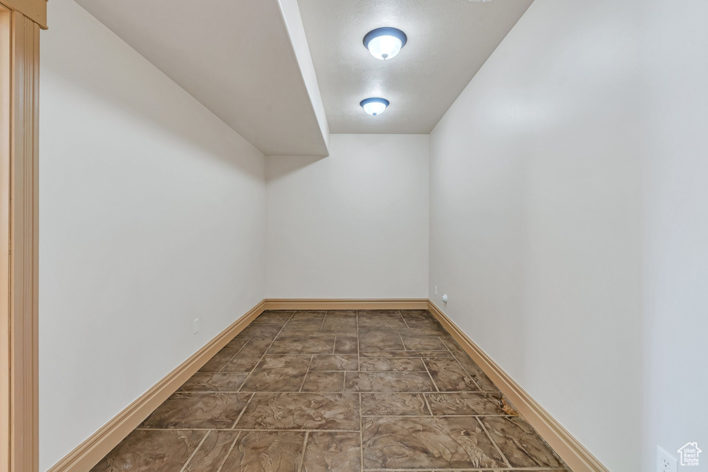 Additional living space with baseboards and stone finish flooring