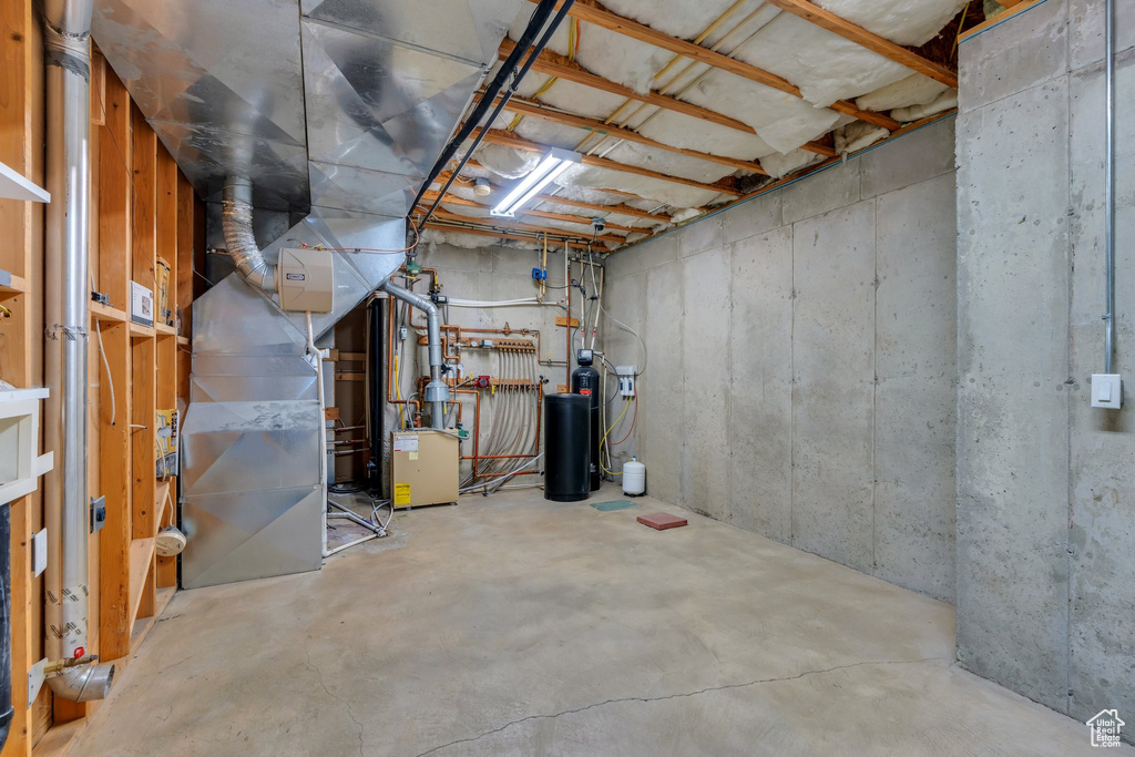 Unfinished basement featuring a water softener system