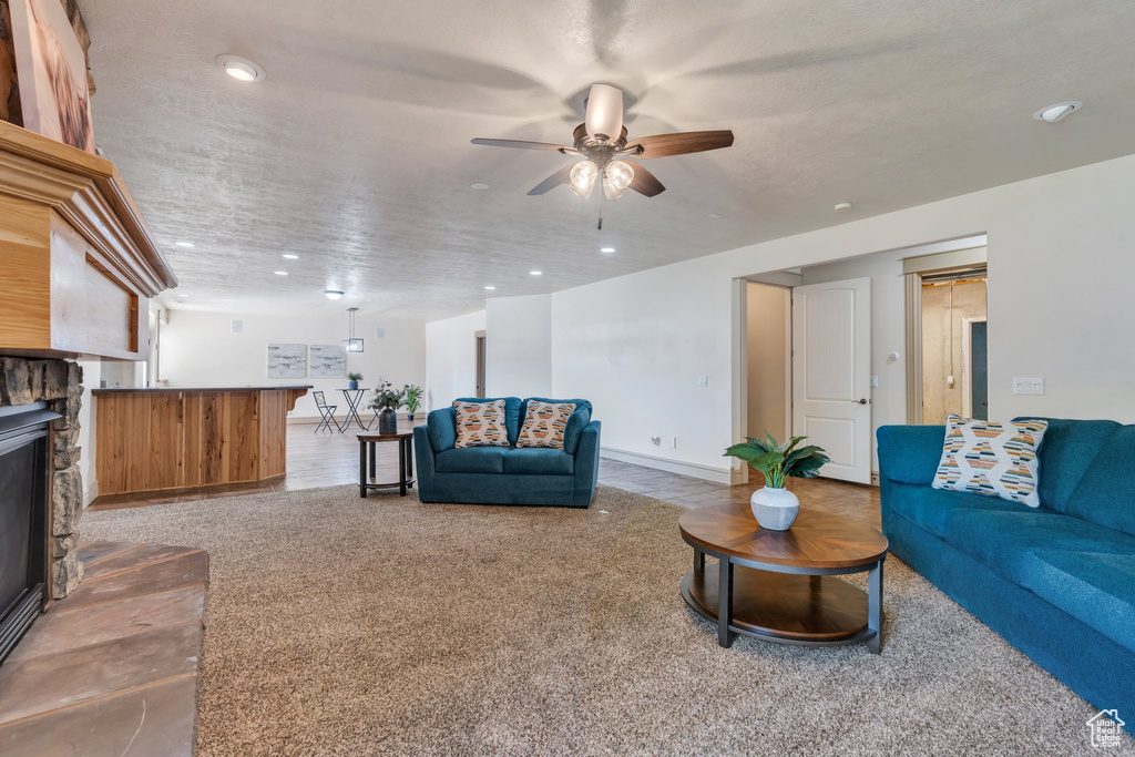 Carpeted living room with ceiling fan, recessed lighting, a fireplace, and baseboards