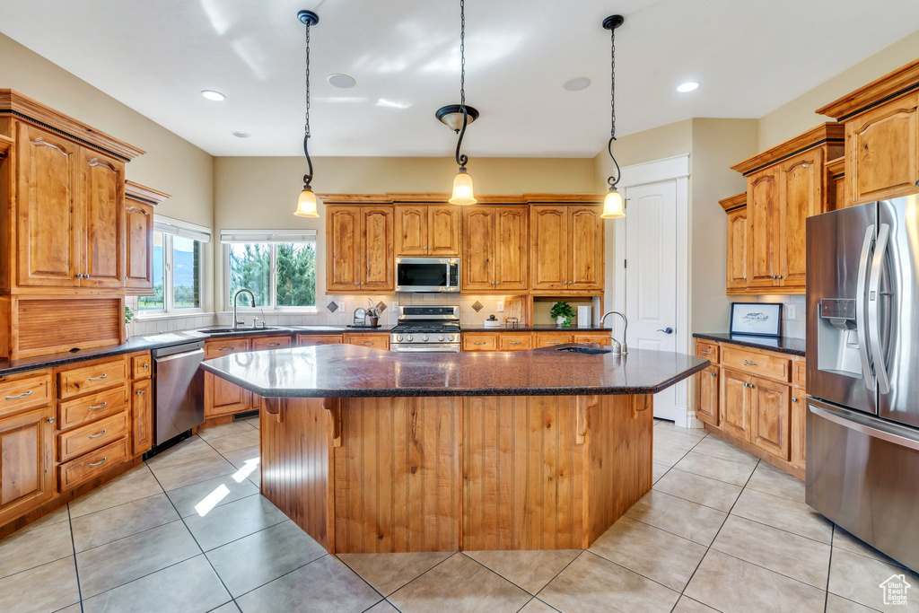 Kitchen featuring stainless steel appliances, a sink, a kitchen island with sink, decorative backsplash, and recessed lighting
