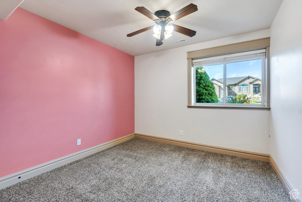 Unfurnished room featuring carpet floors, baseboards, and a ceiling fan
