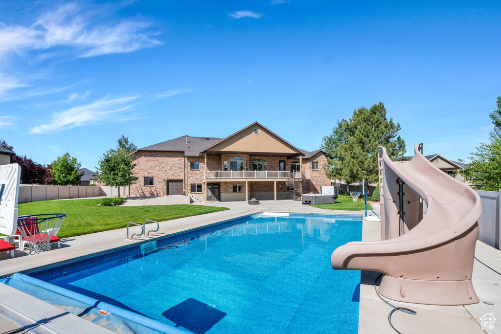 View of swimming pool with a water slide and a patio area