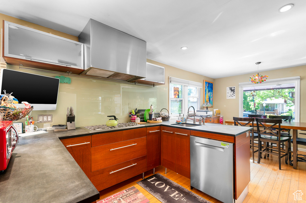 Kitchen featuring appliances with stainless steel finishes, a sink, brown cabinetry, recessed lighting, and a peninsula