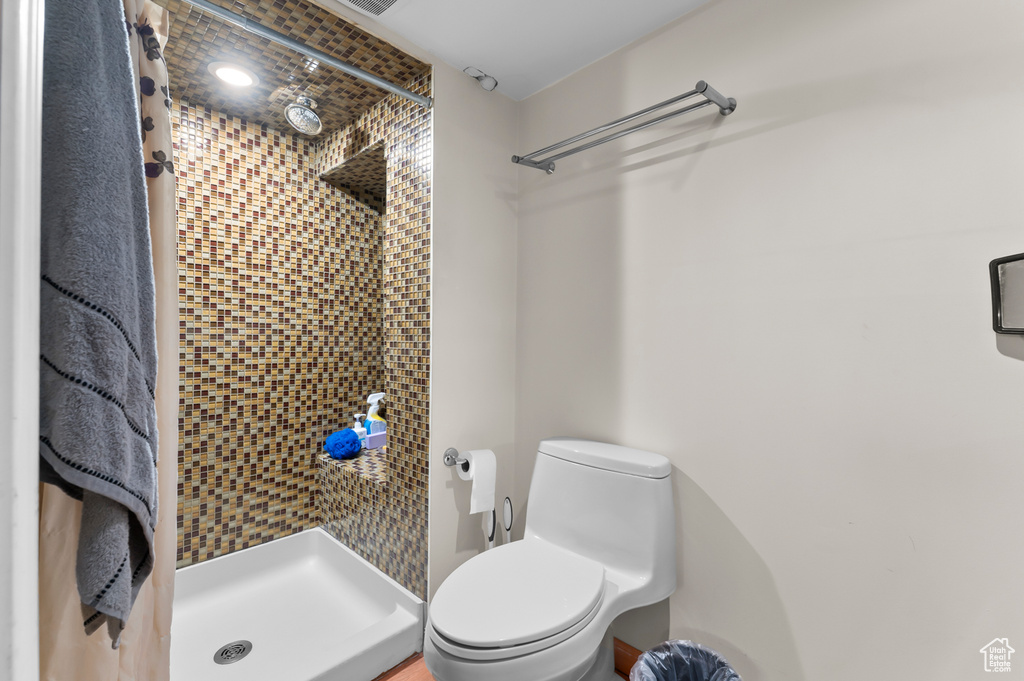 Full bathroom featuring a stall shower and toilet