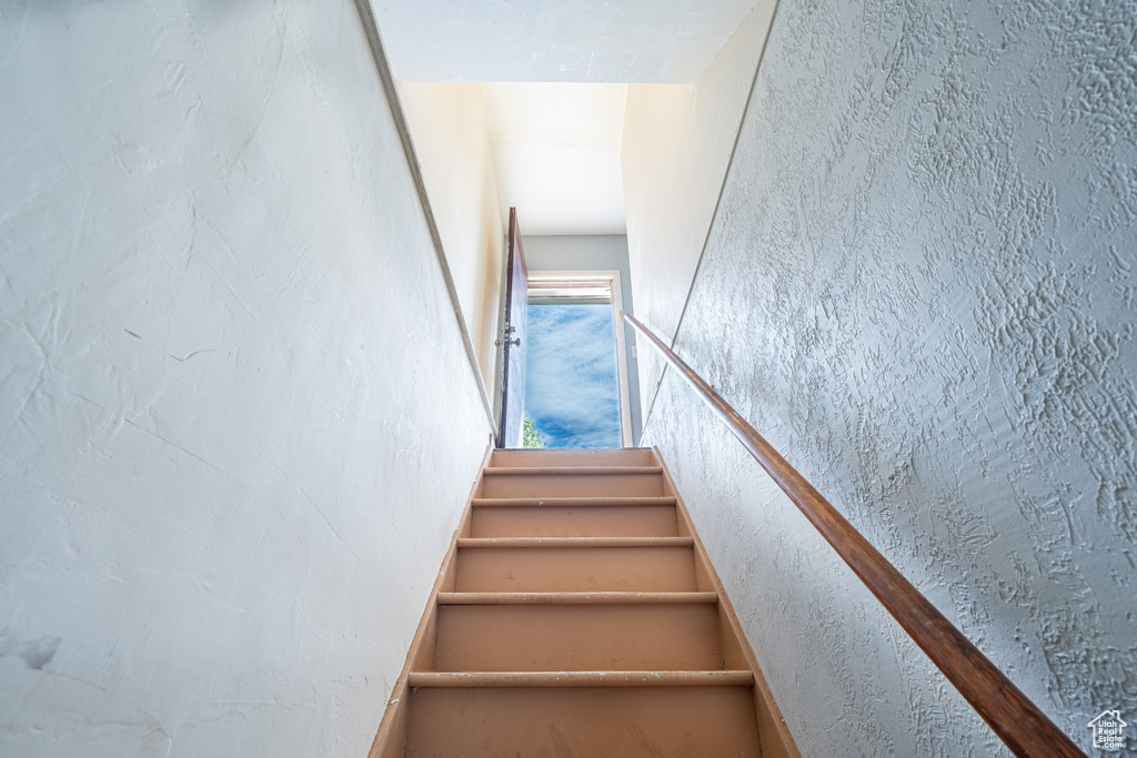 Staircase featuring a textured wall