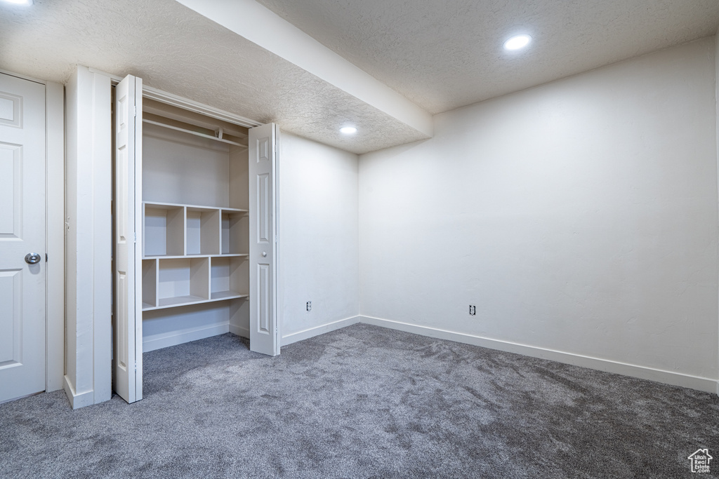 Unfurnished bedroom with carpet, a textured ceiling, baseboards, recessed lighting, and a closet
