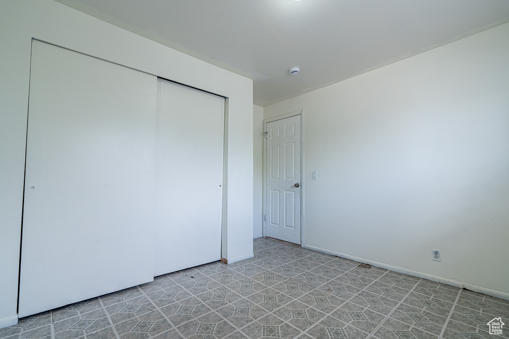 Unfurnished bedroom featuring a closet and light floors