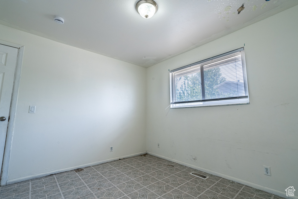 Spare room with a smoke detector and baseboards