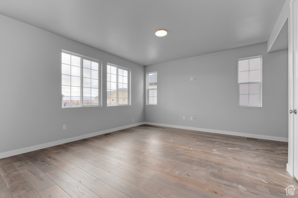 Spare room featuring baseboards and wood finished floors