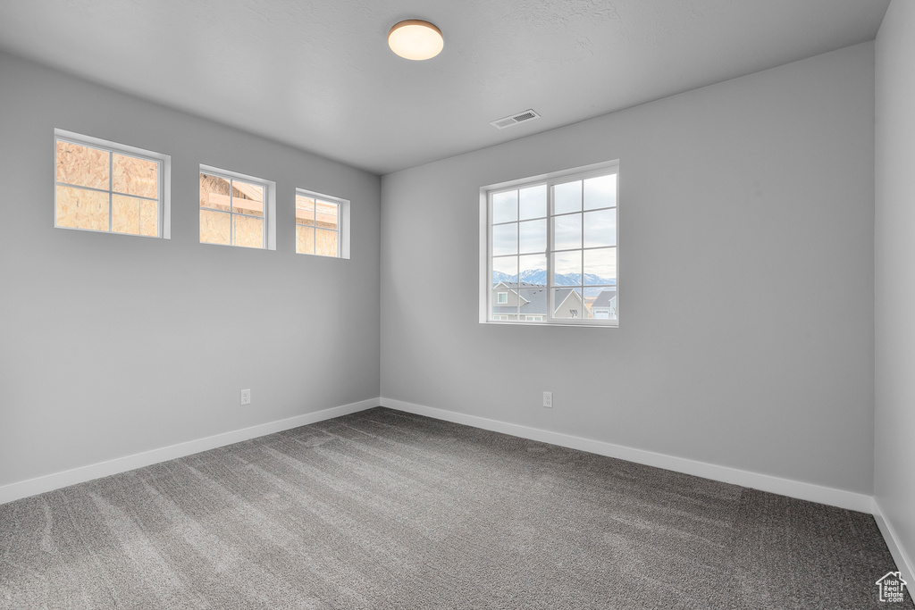 Carpeted empty room featuring baseboards