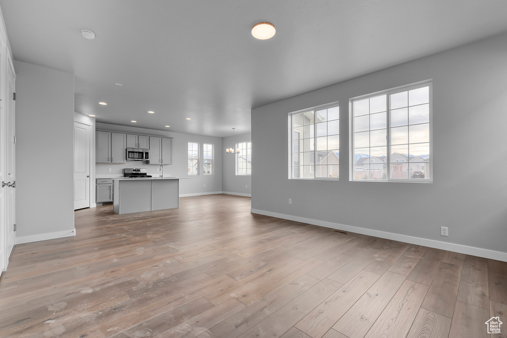 Unfurnished living room featuring baseboards, recessed lighting, and light wood-type flooring
