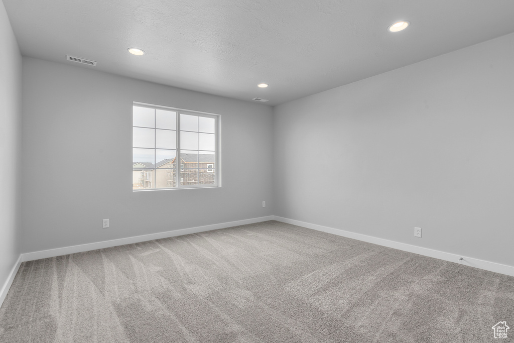 Carpeted empty room featuring baseboards and recessed lighting