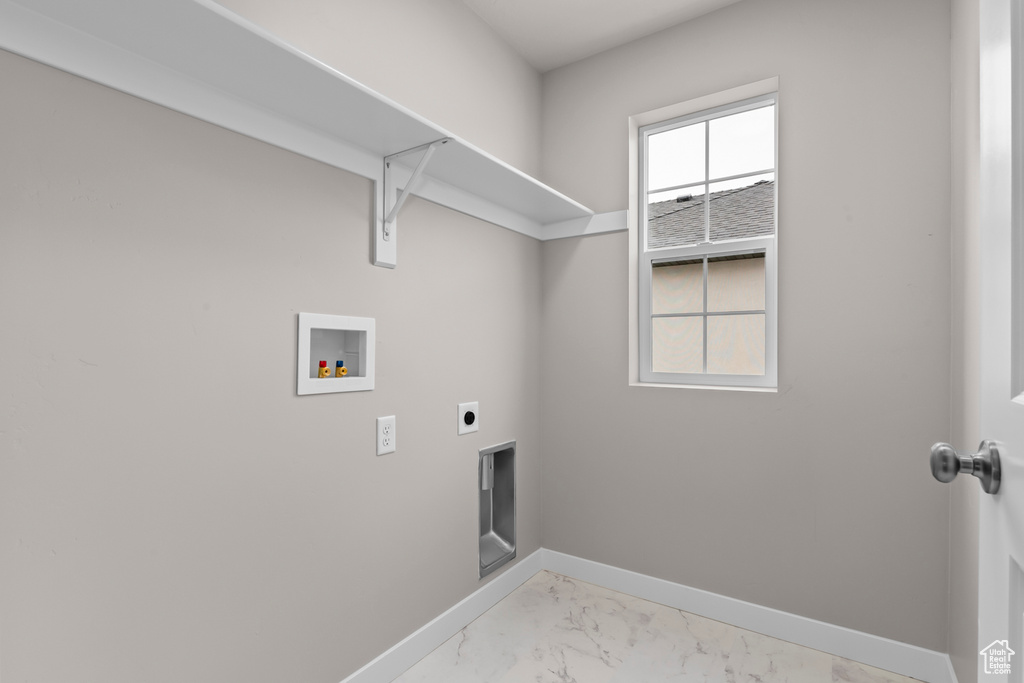 Laundry room with washer hookup, electric dryer hookup, light marble finish floors, and baseboards