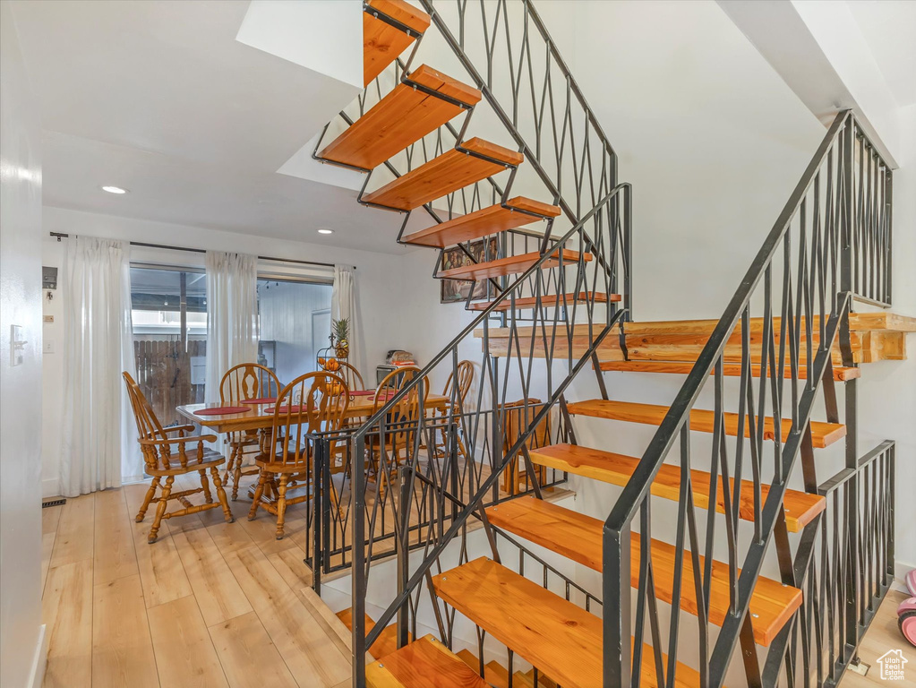 Stairs with hardwood / wood-style floors and recessed lighting