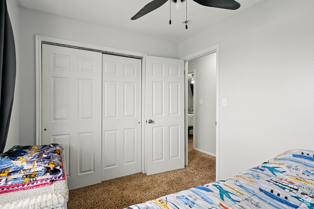 Bedroom with carpet floors, a closet, and ceiling fan