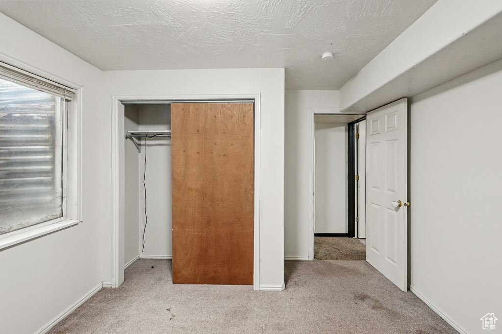 Unfurnished bedroom featuring carpet flooring, a closet, and baseboards