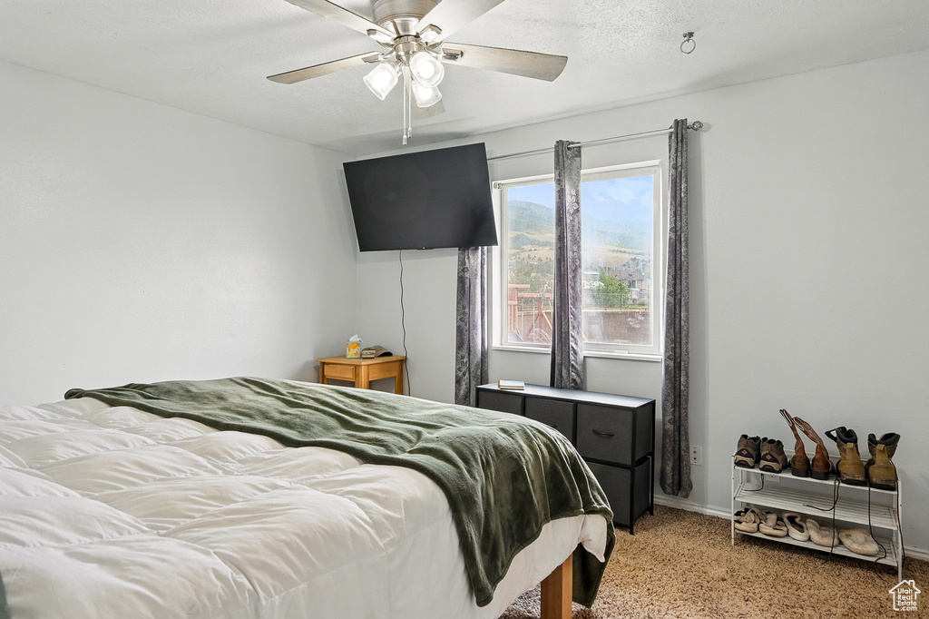 Bedroom featuring light carpet, baseboards, and a ceiling fan