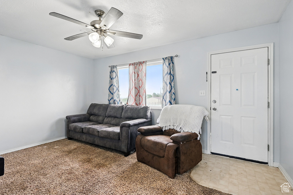 Living room featuring a ceiling fan and baseboards