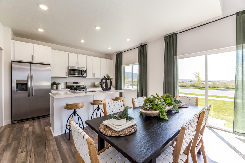 Dining area with dark wood-style floors and recessed lighting