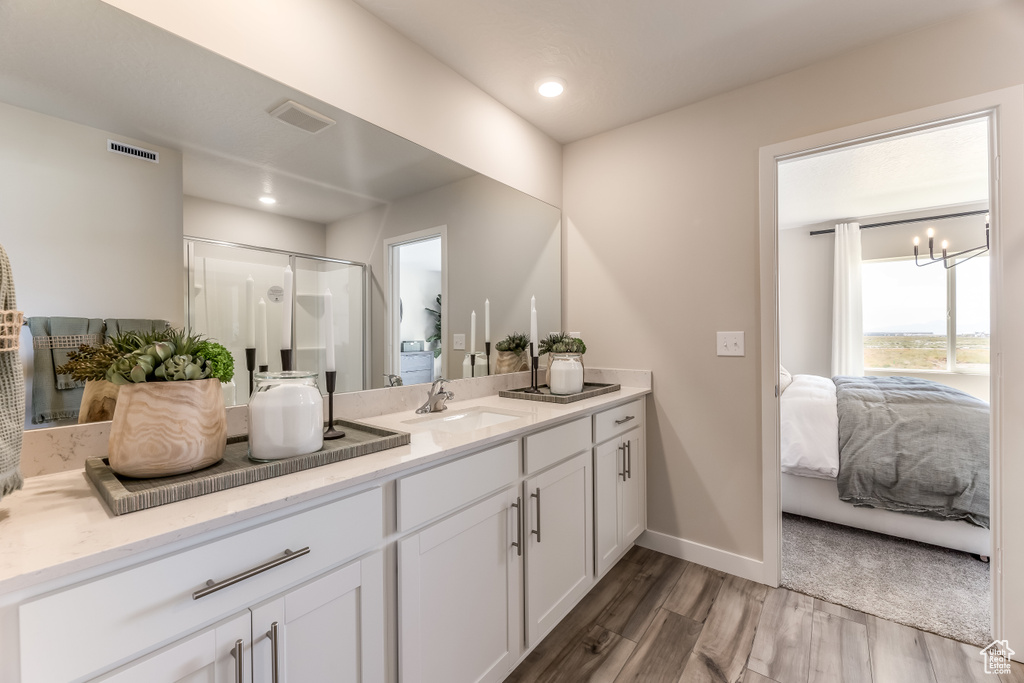 Full bath with connected bathroom, wood finished floors, vanity, a stall shower, and recessed lighting