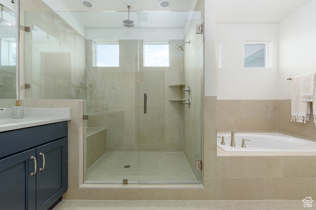 Bathroom featuring vanity, a shower stall, and a garden tub