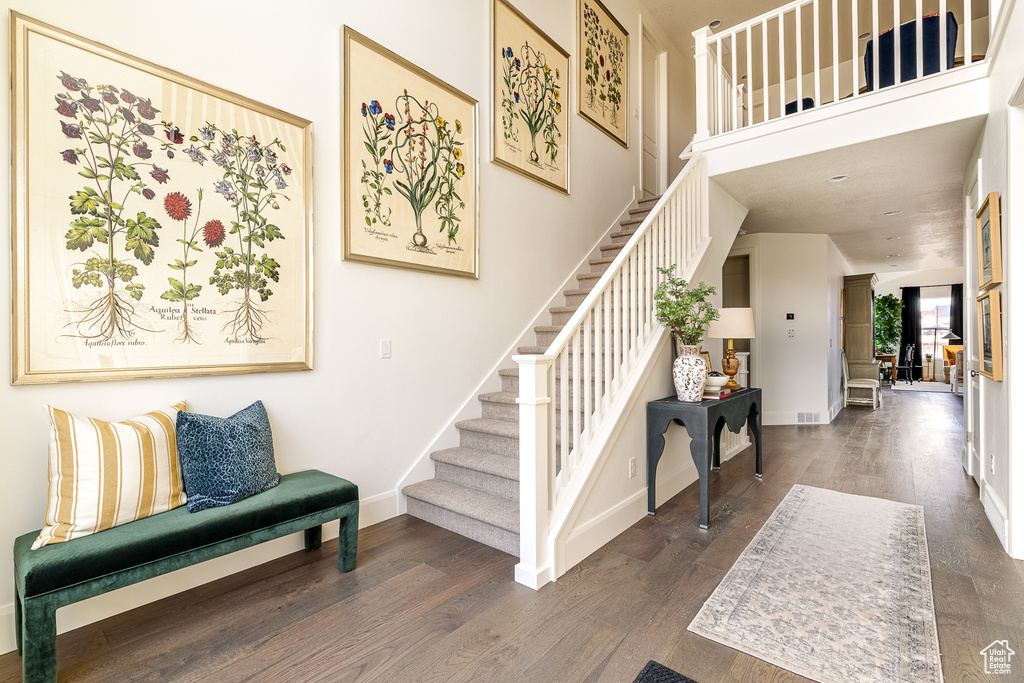 Foyer featuring stairway, wood finished floors, and baseboards