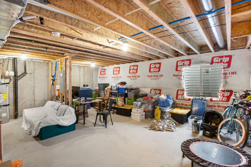 Unfinished below grade area with electric panel and water heater